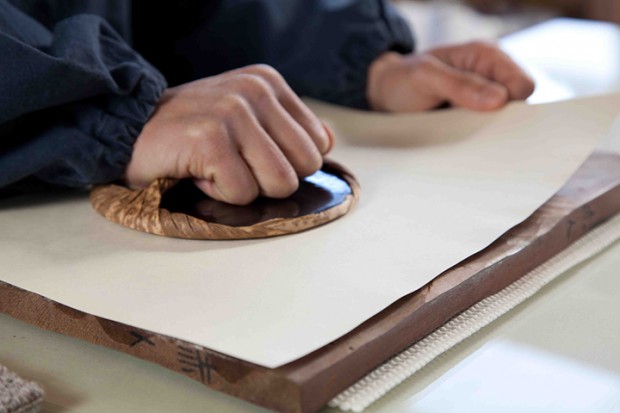 胡粉を引いた紙を乗せ、バレンで摺ります